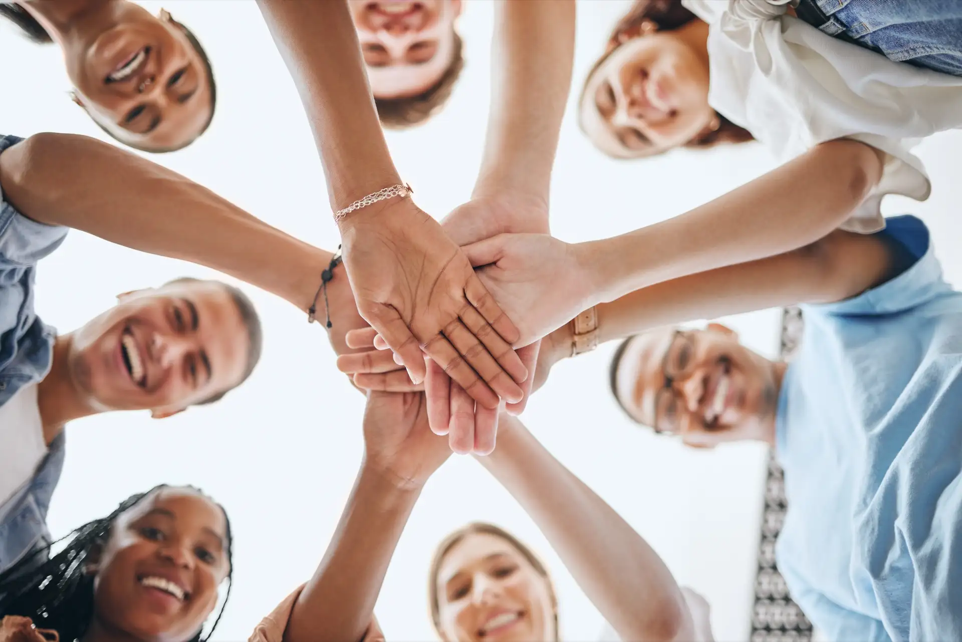 A group of friends stacking hands together in a circle
